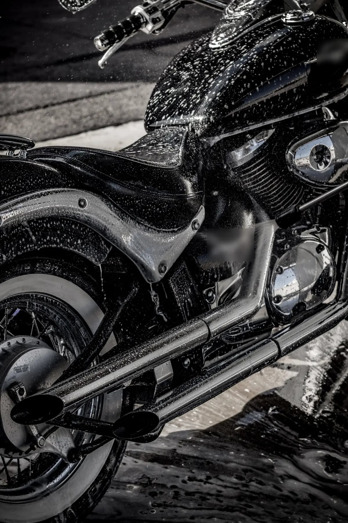 Een natte, zwarte motor na de wasbeurt, met glanzend chroom